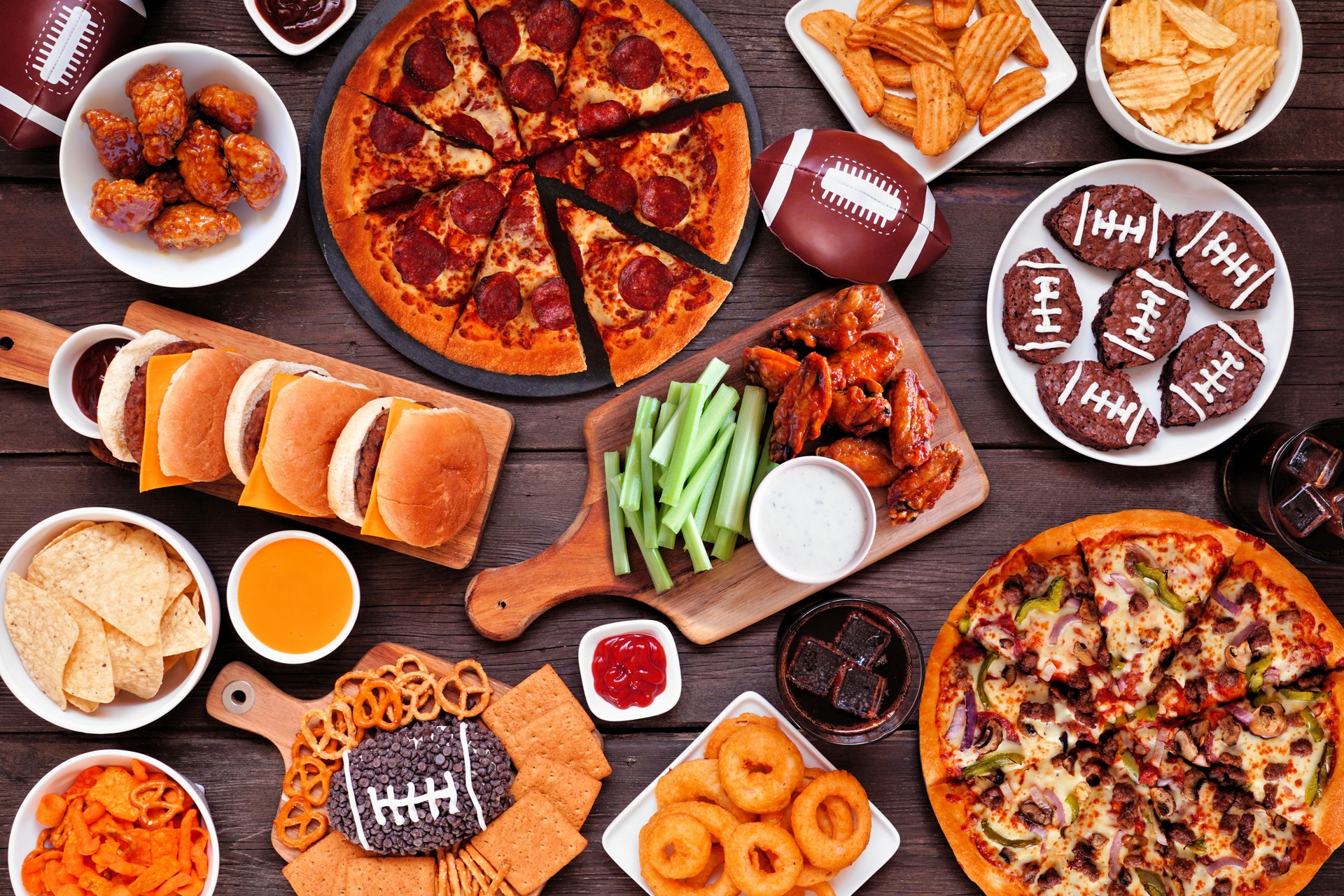 Super Bowl or football theme food table scene, overhead view on dark wood