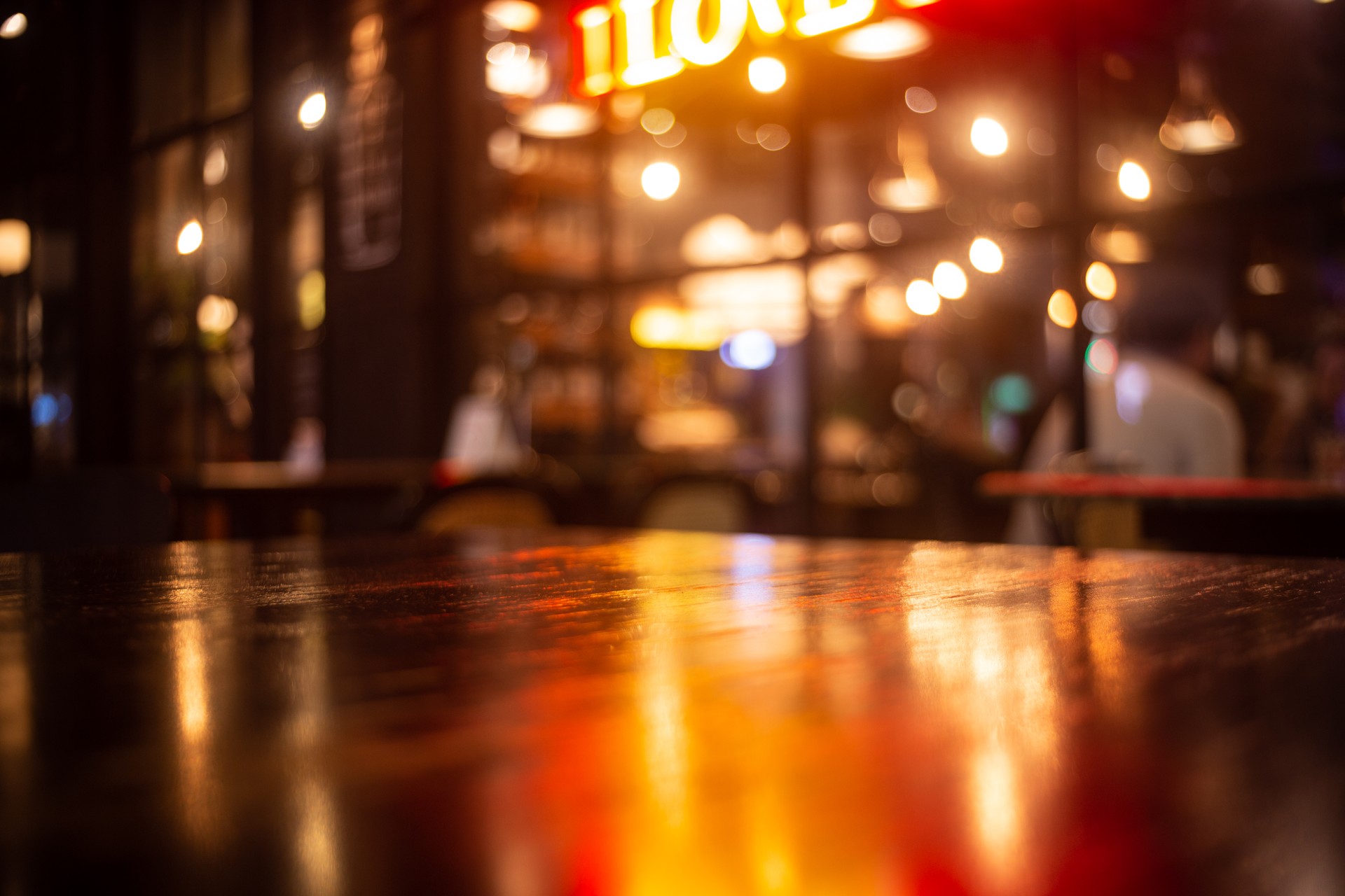 Empty real wood table top with light reflection on scene at restaurant, pub or bar at night.